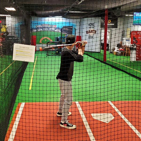 Child enjoying the batting cage at Evolution Sports Excellence in Leduc, AB