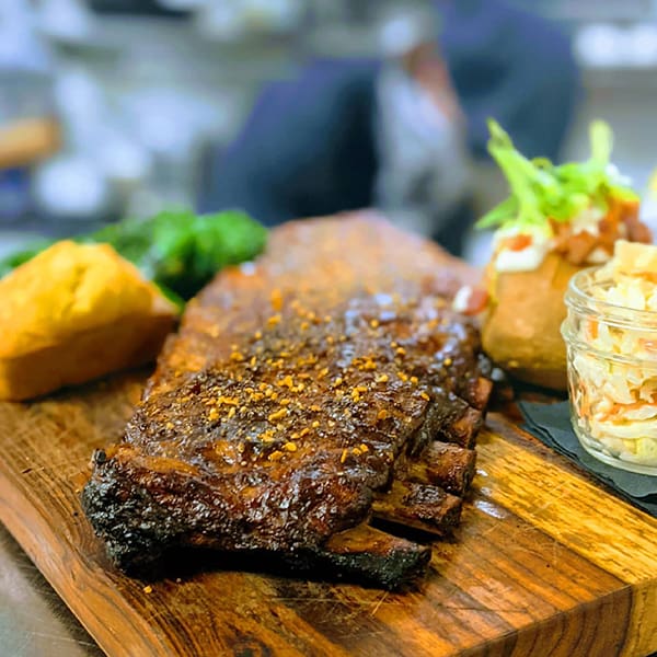 Barney's Butcher Block Special - St. Louis Ribs (Full Rack) served with Broccolini, Baked Potato, Homemade Corn Bread
