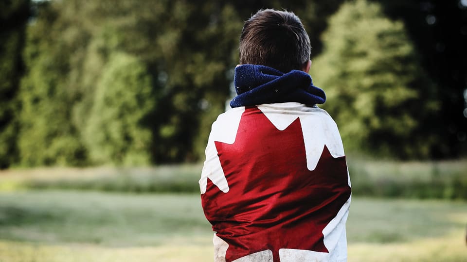 Canada Day flag wrapped around a child's shoulders
