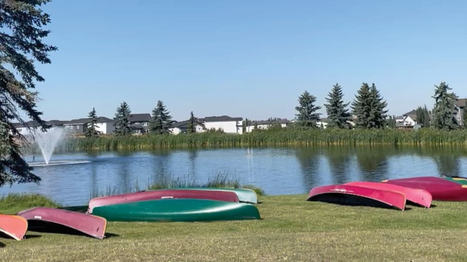 Quiet lake within the park, red canoes laying on the bank